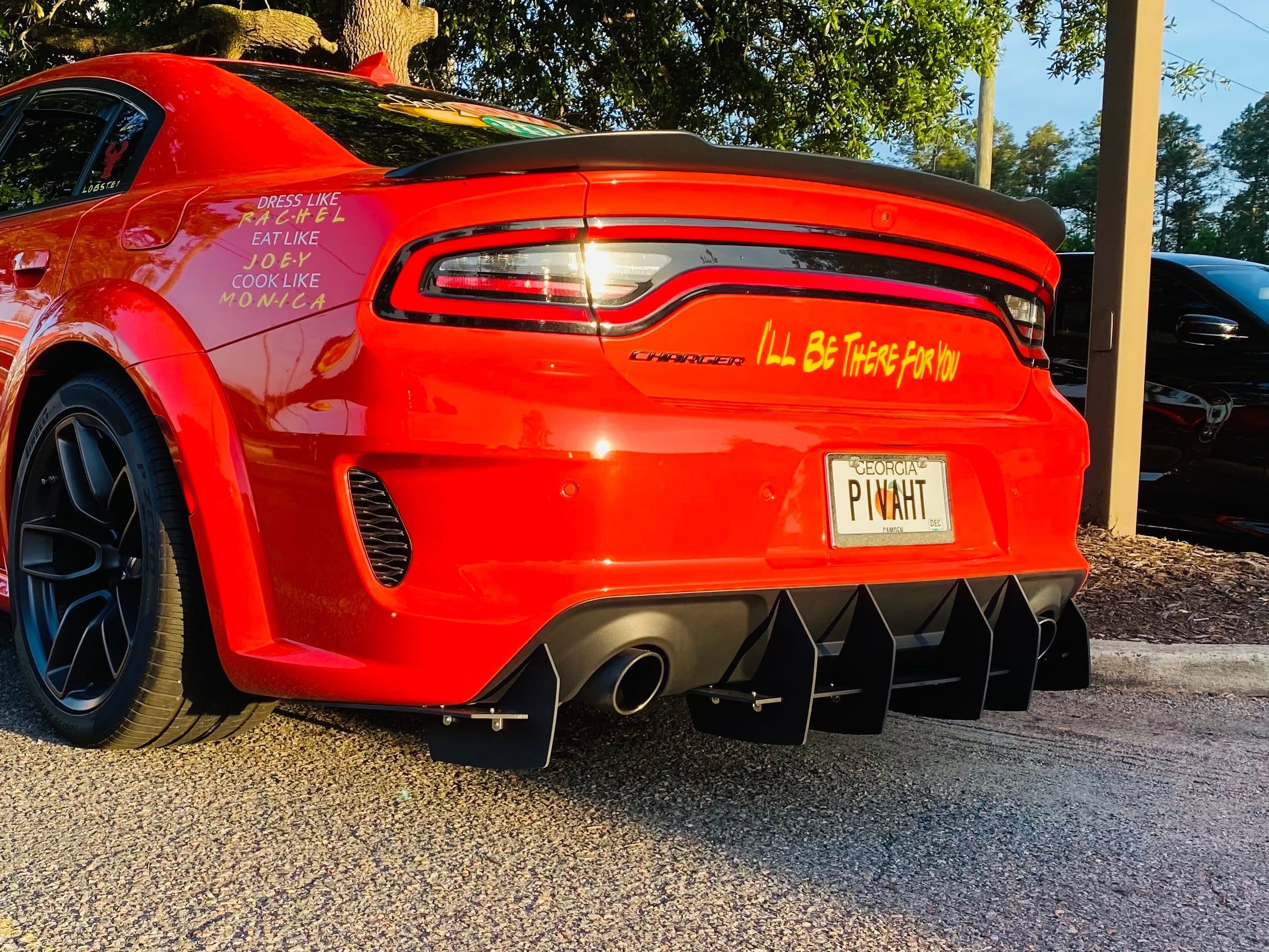 Rear three-quarter view of a Dodge Charger 392 with a performance exhaust system, aftermarket rear diffuser, and dual exhaust tips.