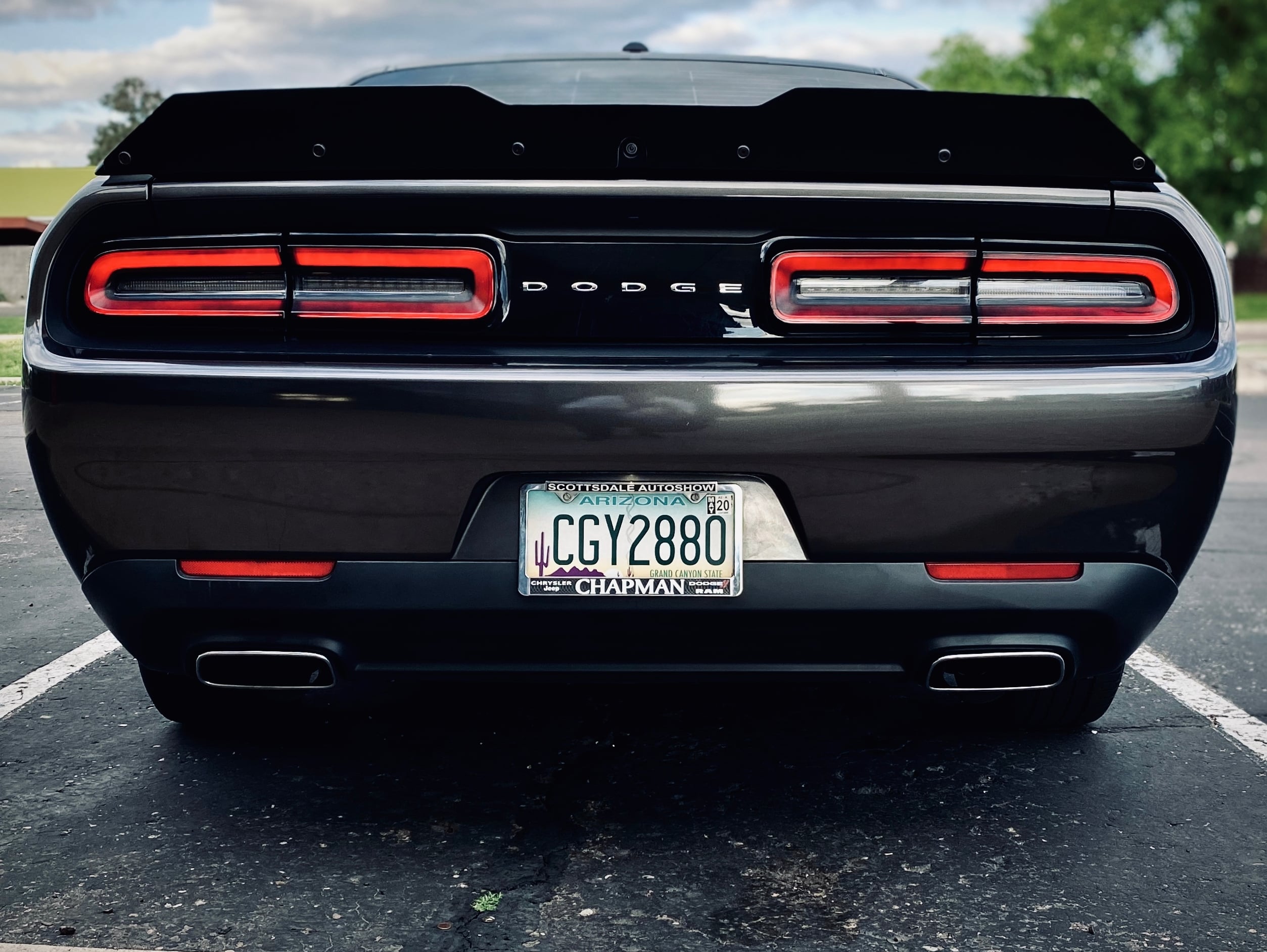 Rear view of a Dodge Challenger with a dual-exit performance cat-back exhaust system, featuring rectangular polished exhaust tips integrated into the rear valance.